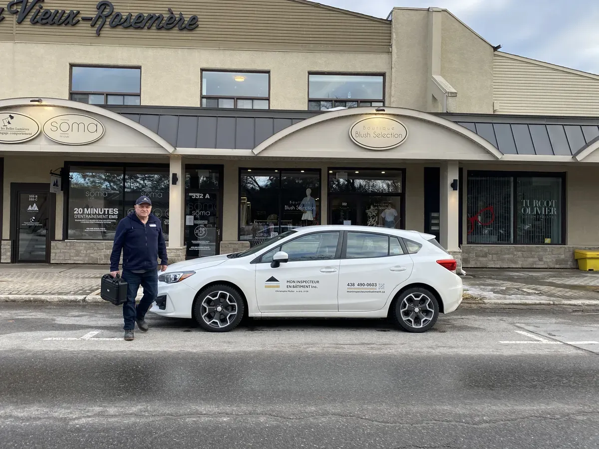 Christophe Muller, inspecteur en bâtiment certifié, devant son véhicule d'inspection à Rosemère