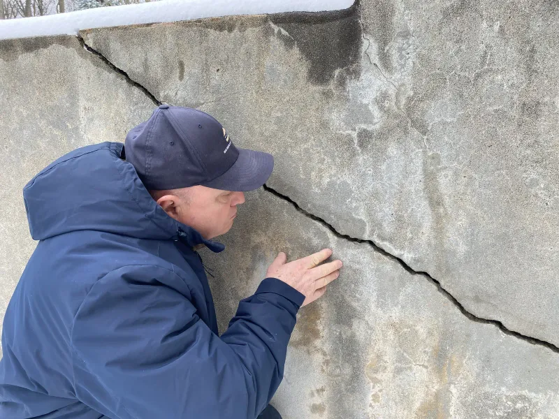 Observation d'une fissure sur un mur de soutènement lors d'un état des lieux à Rosemère