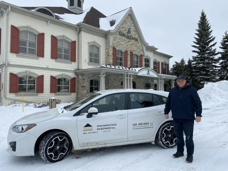 Inspecteur en bâtiment certifié selon la norme BNQ 3009-500 devant le Chalet des Citoyens à Bois-des-Filion avec son unité mobile.