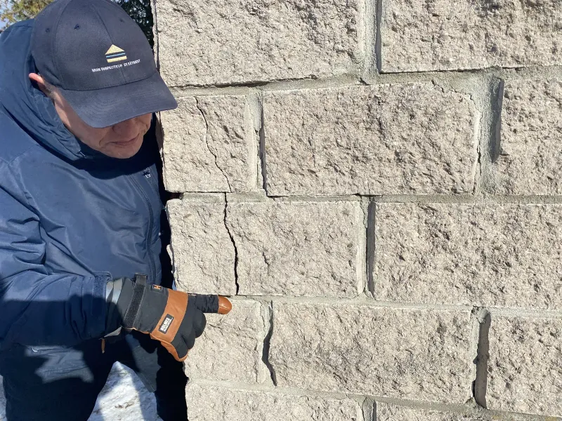 Inspecteur en bâtiment de Mon Inspecteur en Bâtiment analysant une fissure sur un mur du golf à Lorraine.