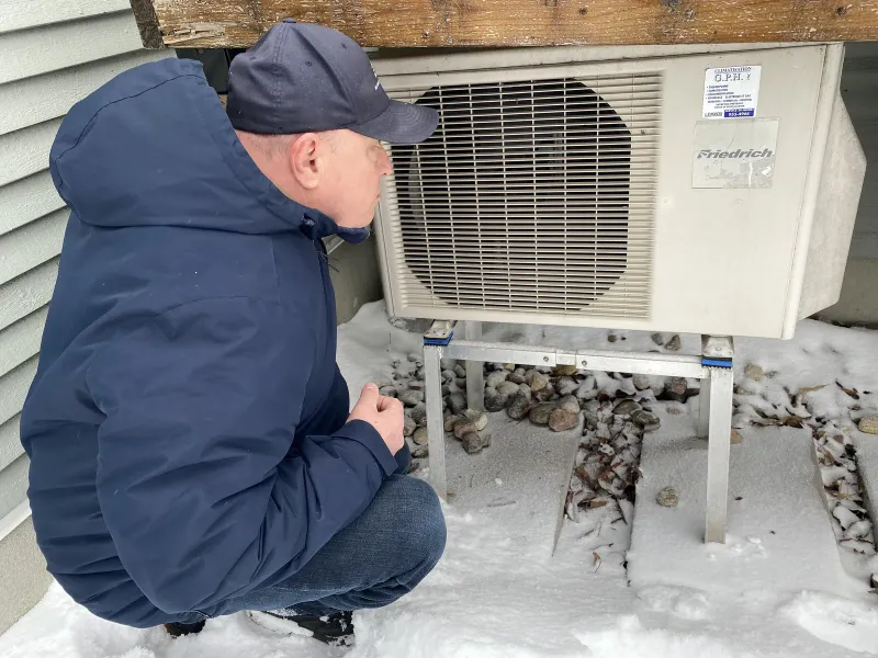 Mon Inspecteur en Bâtiment regardant une thermopompe protégée par un abri à la maison Limoges-Perron à Bois-des-Filion