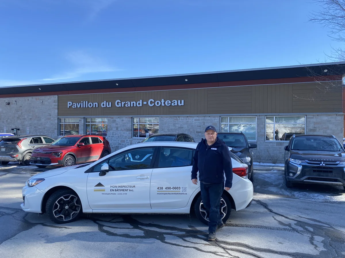 Inspecteur de Mon Inspecteur en Bâtiment Inc. avec son véhicule devant le Pavillon du Grand-Coteau à Mascouche.