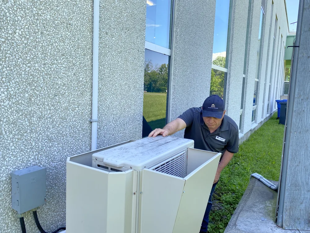 Inspecteur en bâtiment à Lachenaie observant l'installation d'une thermopompe près de la bibliothèque municipale de Lachenaie.