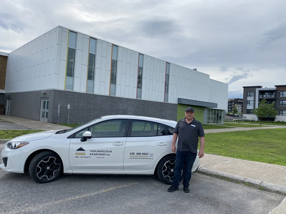 Inspecteur en bâtiment à Urbanova, Terrebonne, avec son unité mobile devant l'École de l'Espace-Couleurs.