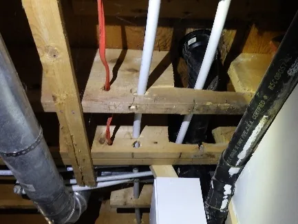 Examen de la charpente, des solives et des poutres dans l'entretoit d'une maison à Bois-des-Filion.