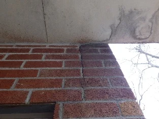 Inspection des murs de brique d'un bâtiment à Sainte-Thérèse pour vérifier l'état de l'enveloppe d'un condo.