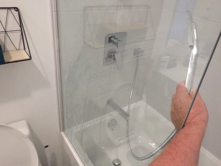 Vérification de l'écoulement de la robinetterie, de l'évacuation du drain et de l'étanchéité de la cabine de douche par l'inspecteur en bâtiment.